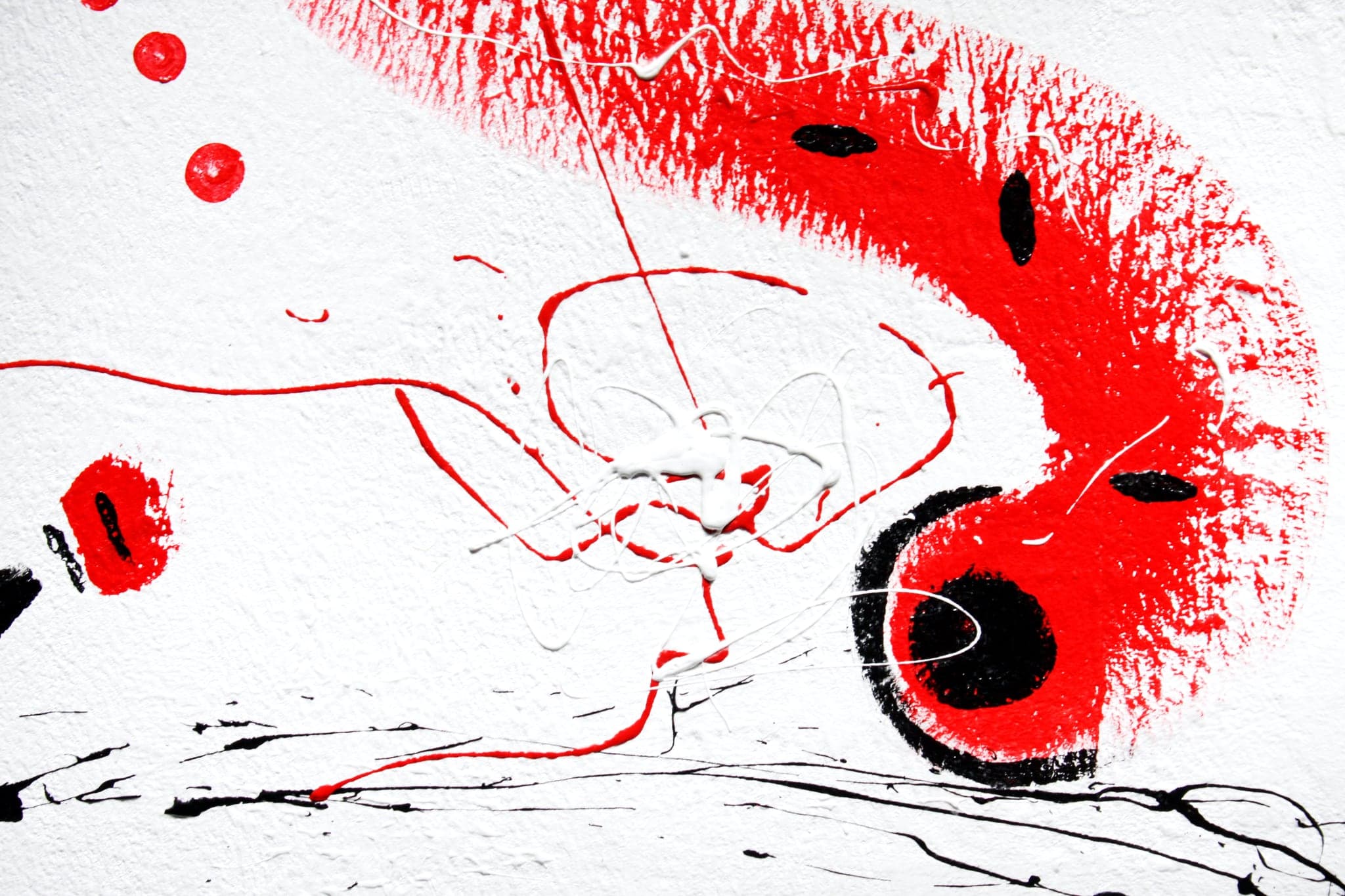 Close view of a broad red sweep across white canvas with black lozenges lying in it and a red and black eye at its end