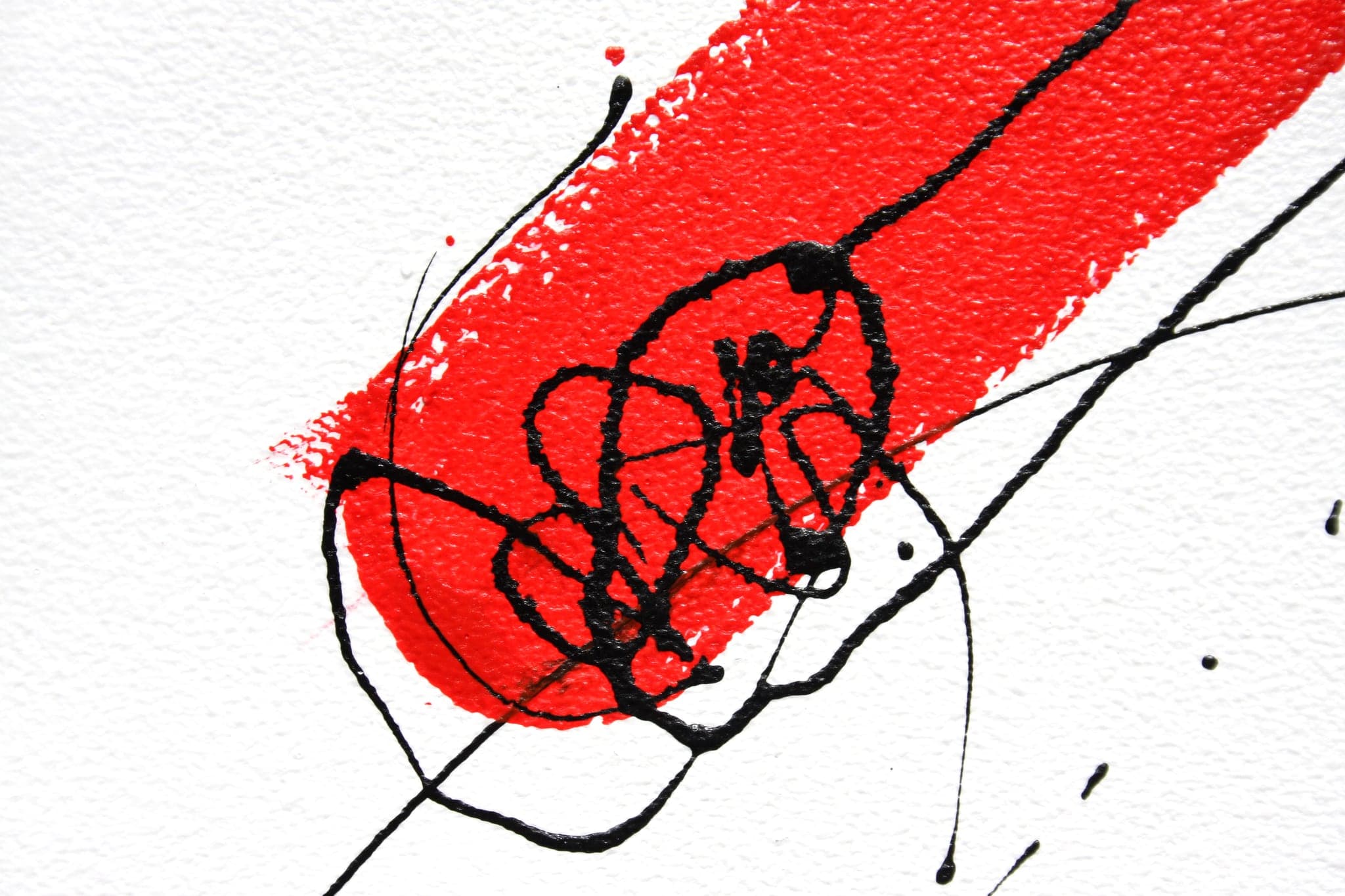 Close view of a black scribbled knot drawn over a thick red diagonal bar