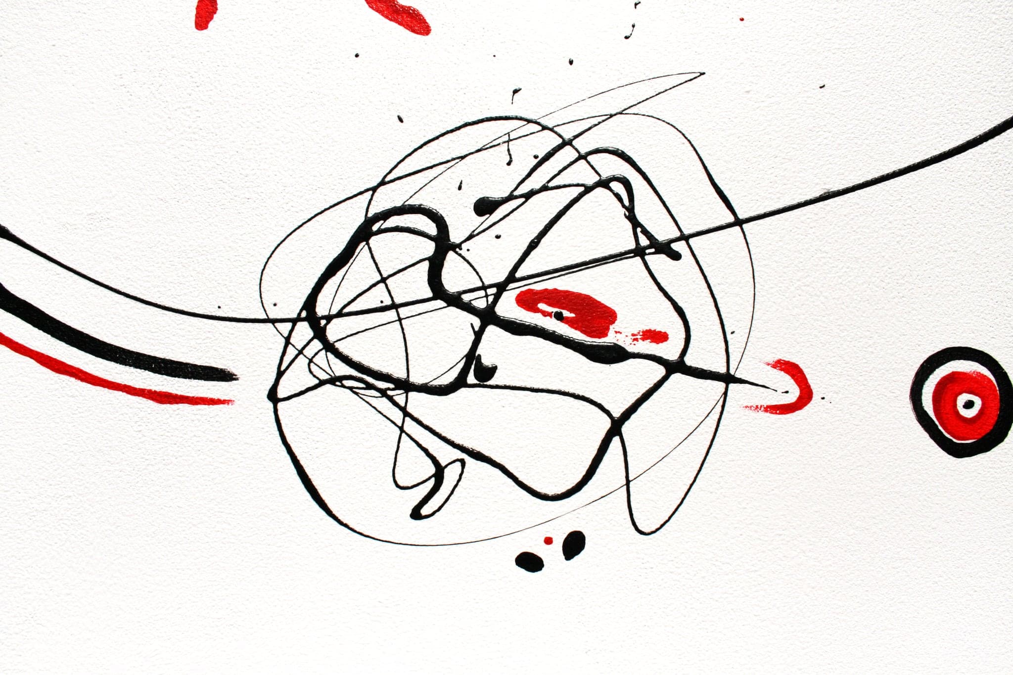 The same kind of black scribbled knot on bare white canvas, with a small ringed target to its right