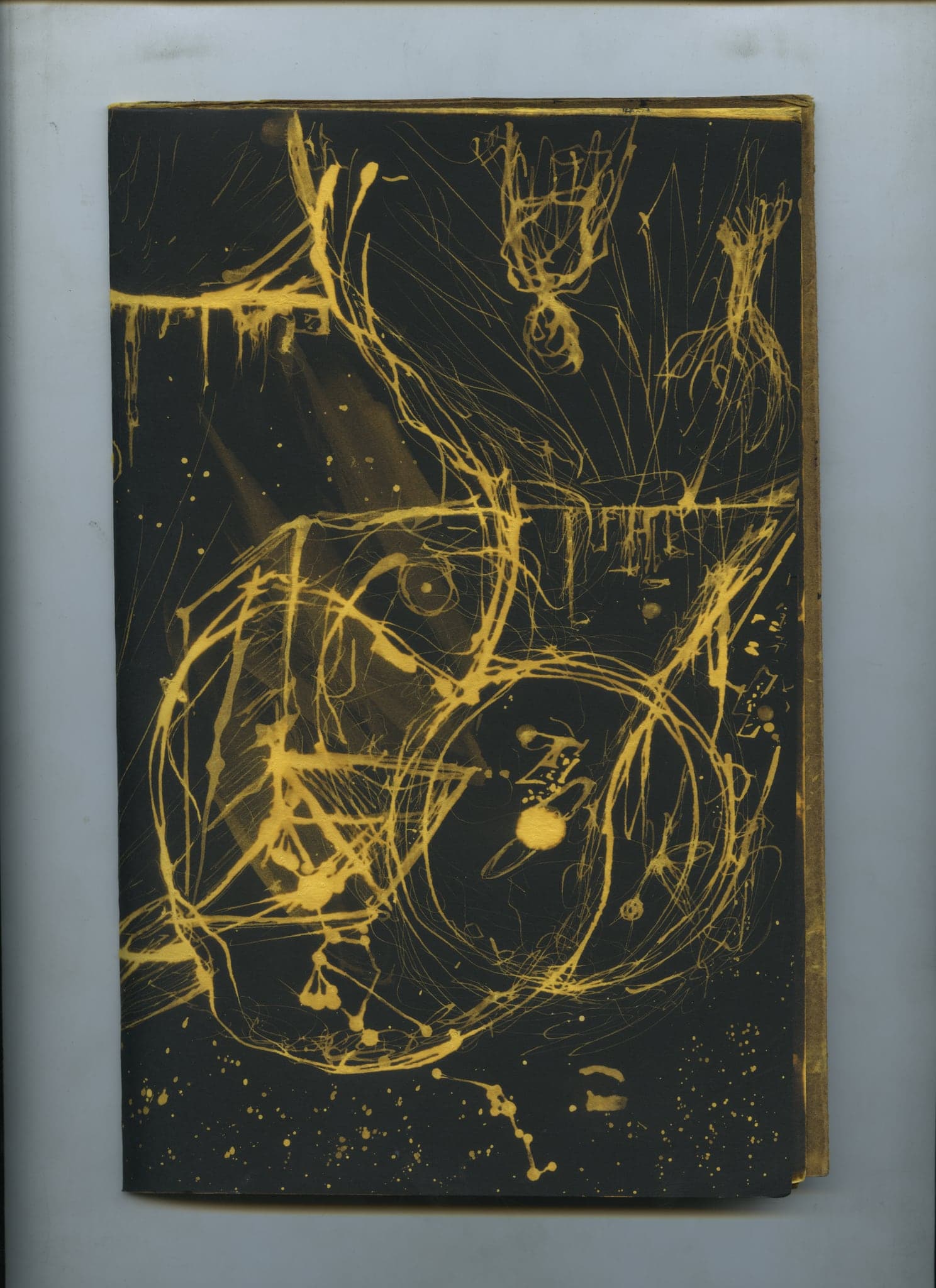A double page almost entirely covered in a dense web of gold bleach lines, small figures caught inside it, the black paper surviving only at the edges