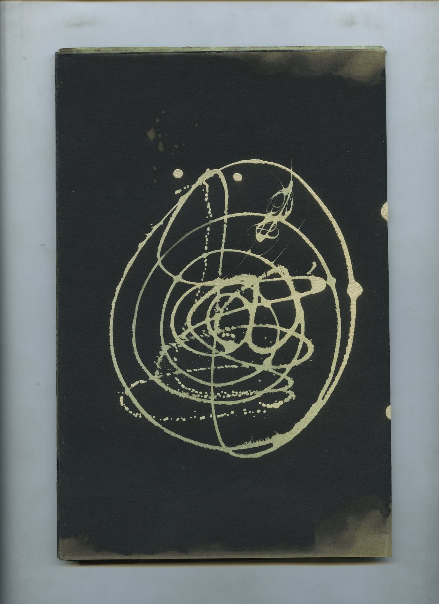 A single pale spiral wound round itself at the centre of an otherwise empty black spread