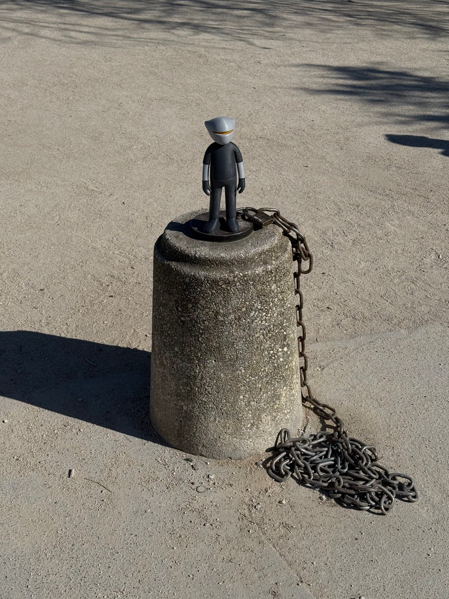 Mr. B standing on a stone mooring drum beside the water, a heavy chain coiled at its base