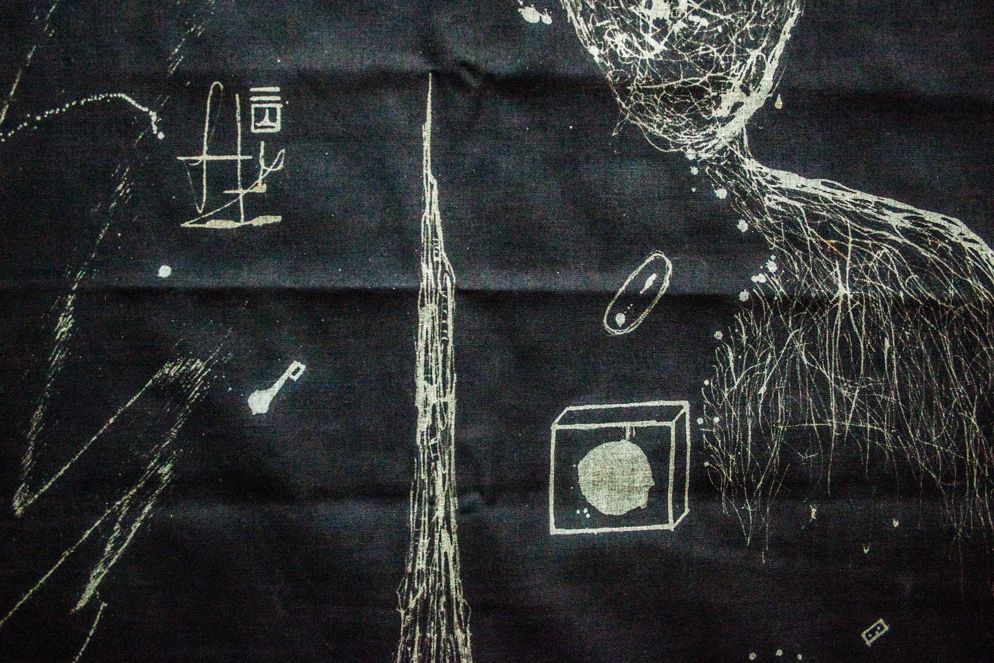 Close view of the same cloth: a pale spire runs floor to ceiling of the frame, a drawn cube holds a soft disc, and fine root-like sprays fall from the upper right. The weave of the cloth is visible through every stroke.