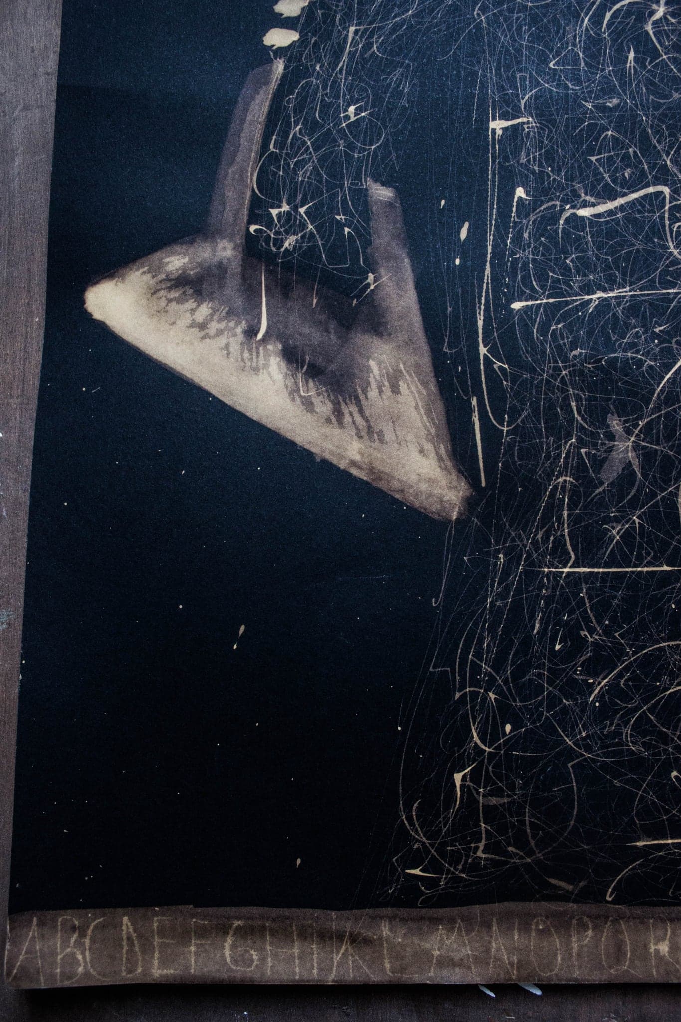 A pale wedge pointing down into the sheet, fine webbing spreading behind it.