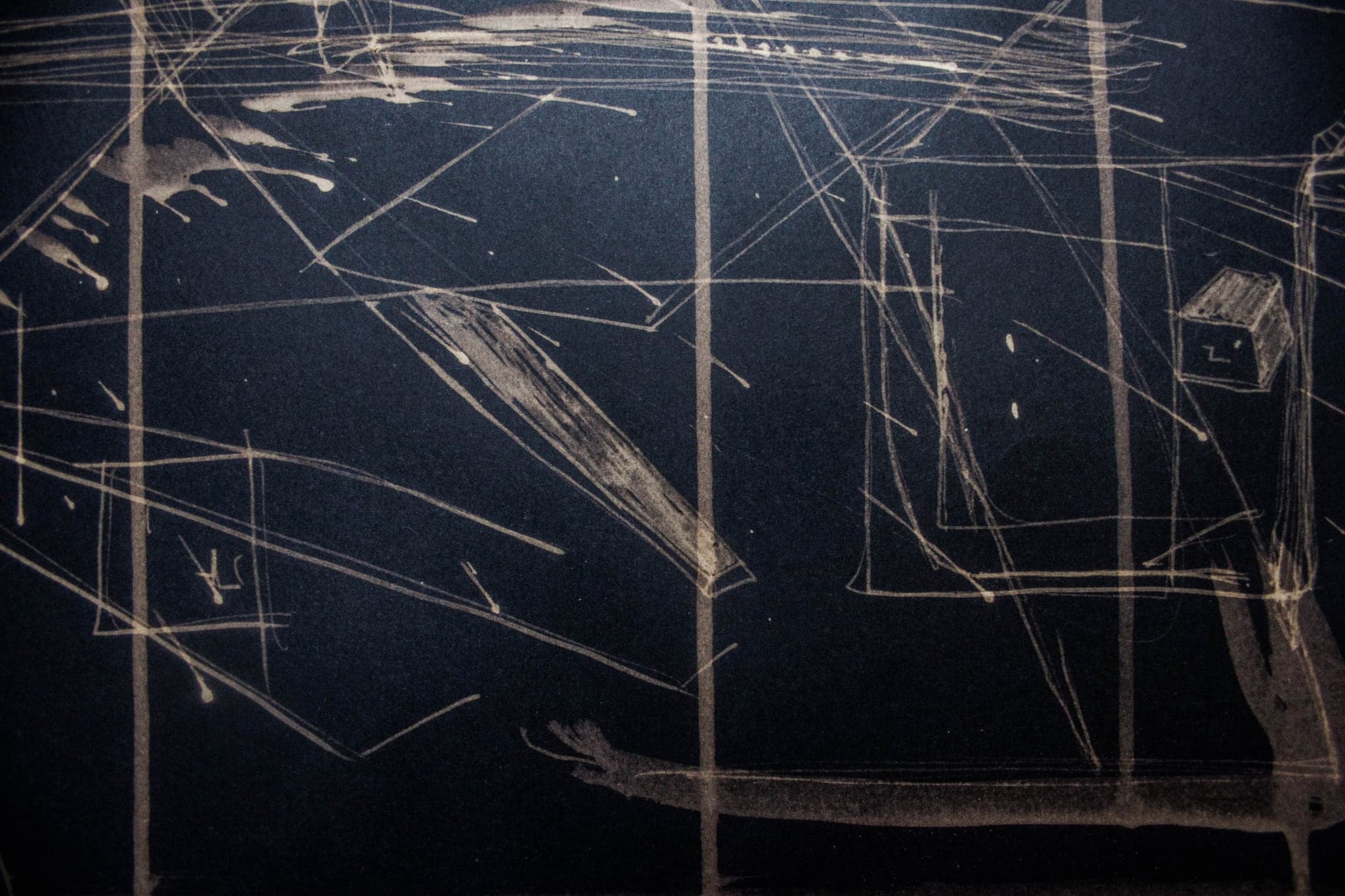 A wide dark sheet crossed by faint straight lines with one soft glow at the centre.