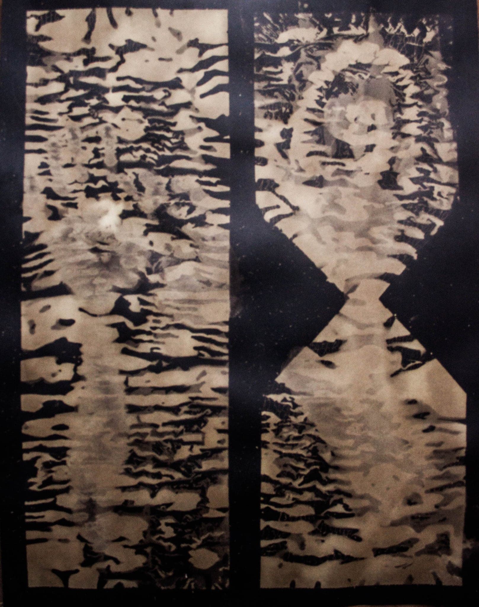 Two tall panels of torn dark bands, a face at the top of one and another at the foot.