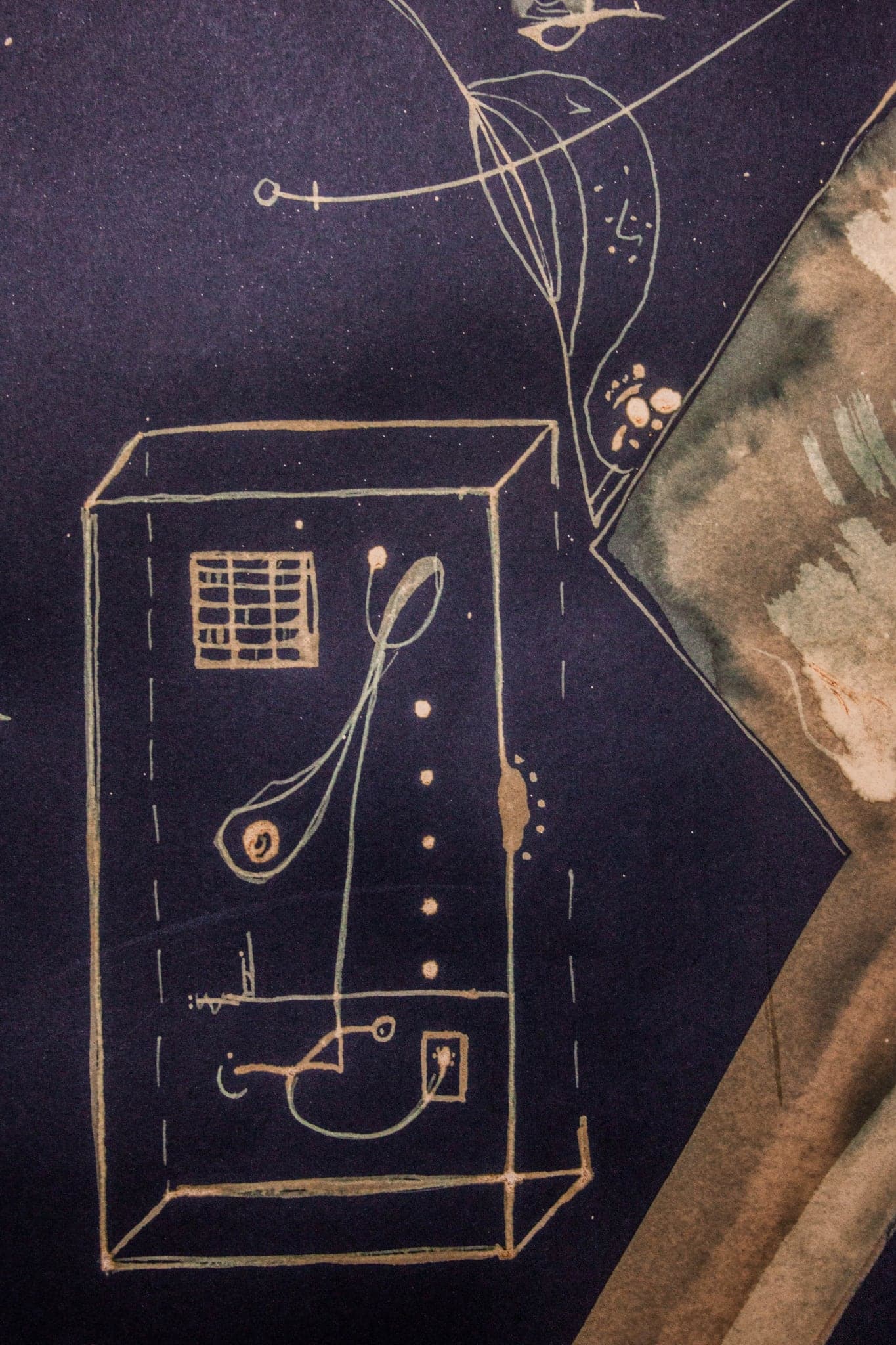 A drawn machine in a box with a spoon-shaped arm, in gold on dark blue.