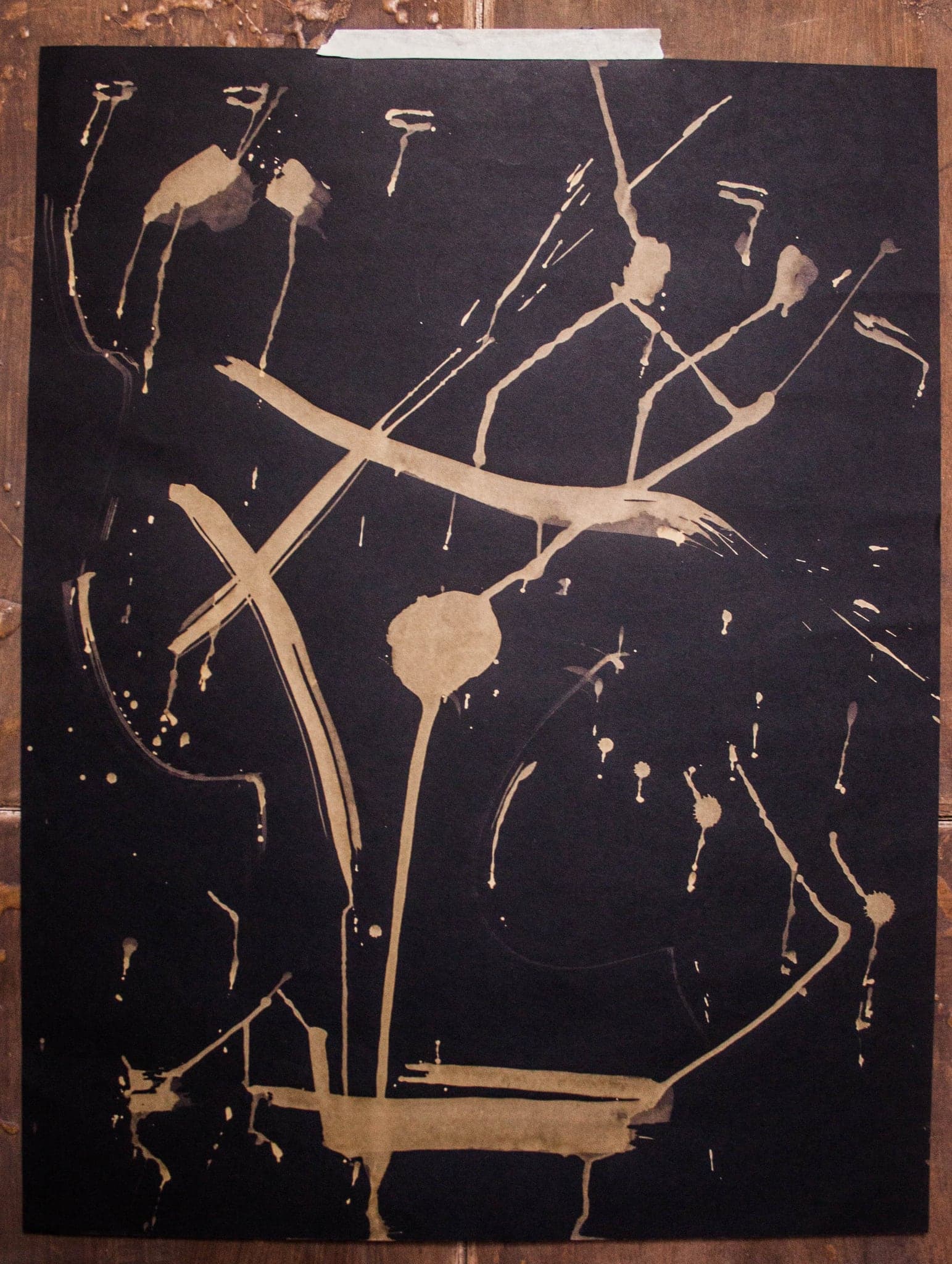 A framed sheet crossed by two long lines, with soft warm blobs caught at their meeting.