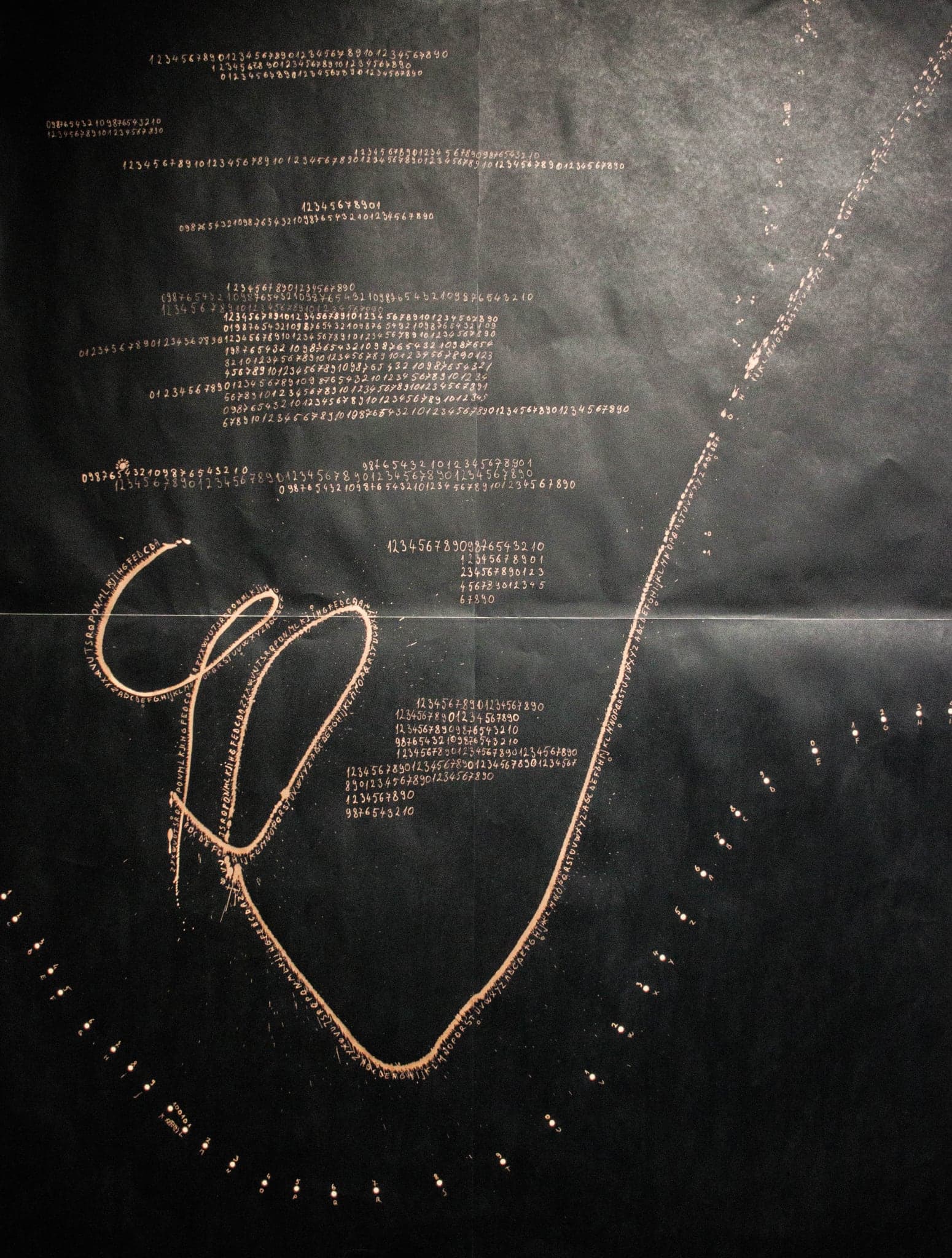 A gold loop and a beaded arc on near-black, with a block of small writing above.