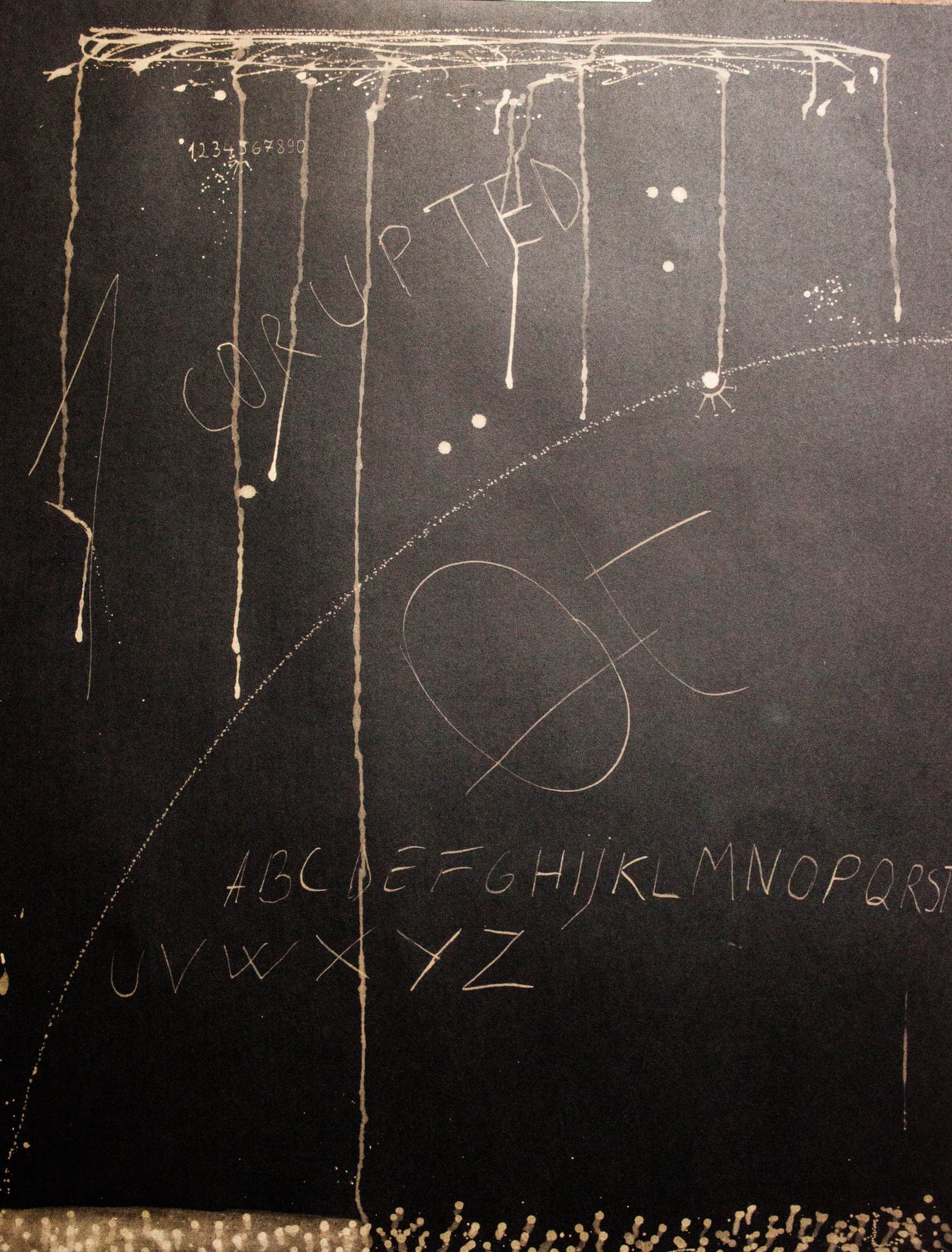 Fine lines hanging down the sheet with a full alphabet written along the bottom edge.