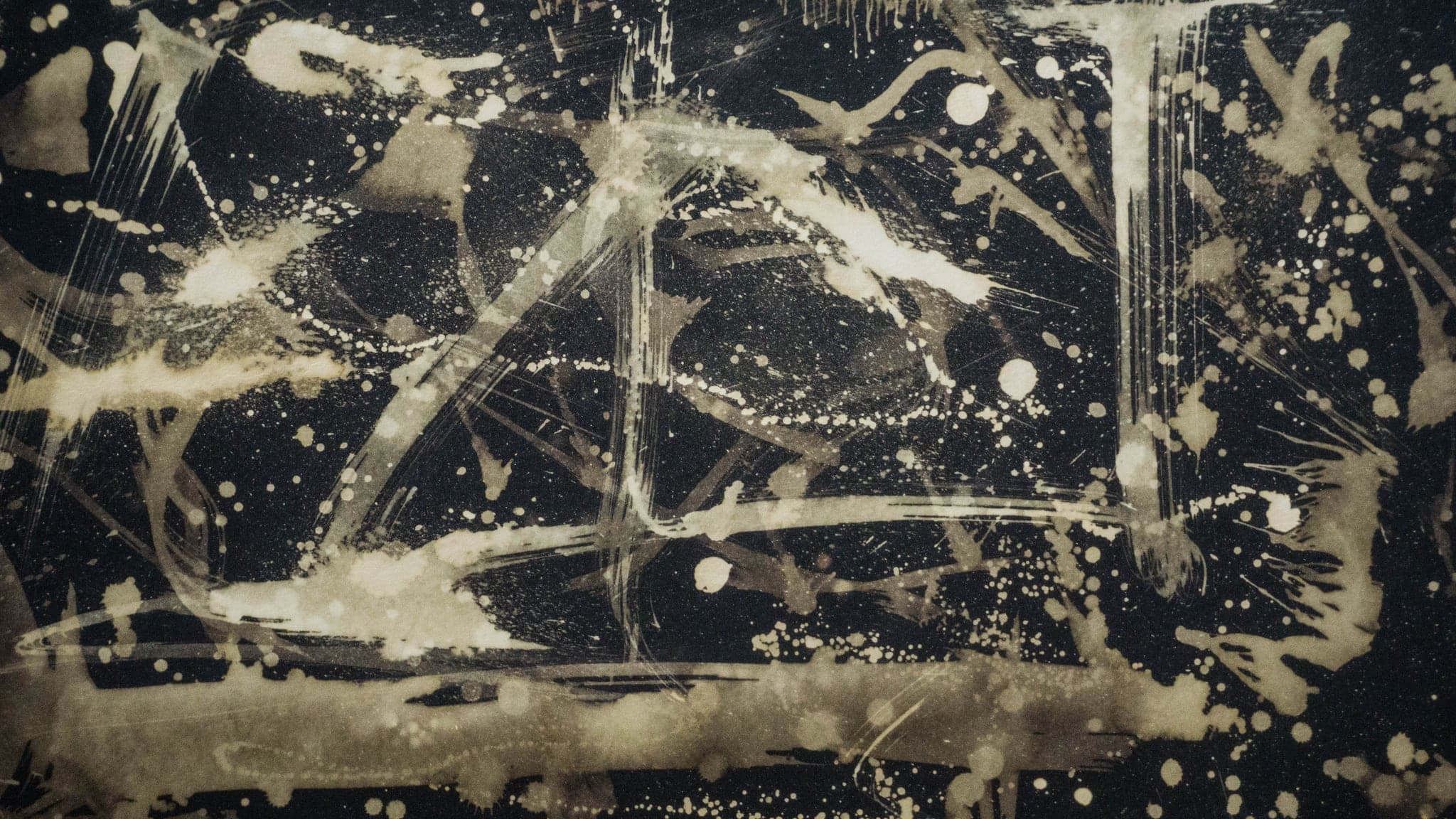 A dark sheet of pale strokes and flung droplets, a long diagonal running through them.