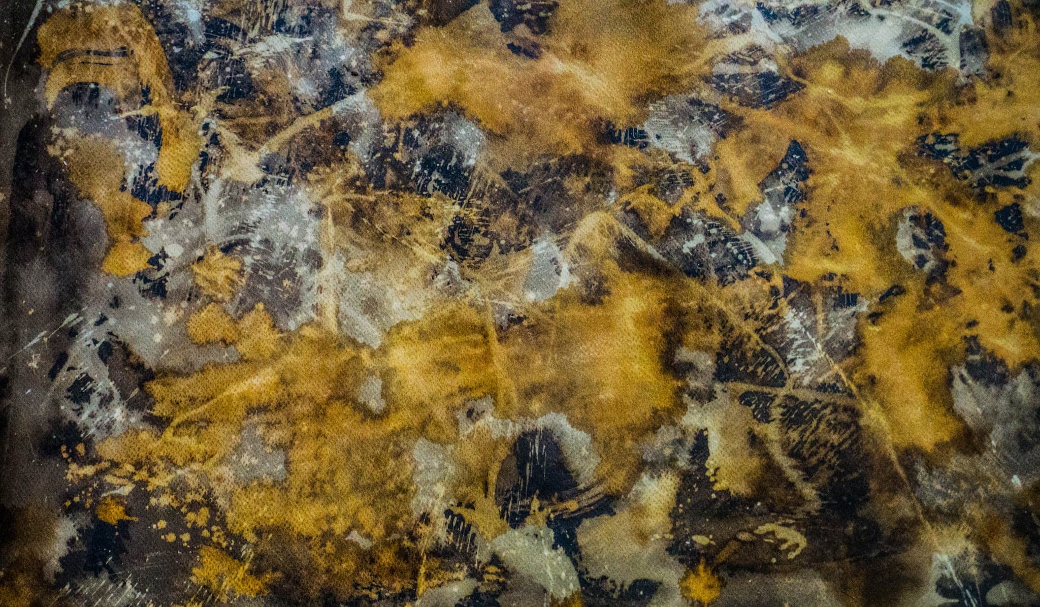 Close on one heavily worked surface: gold blooms opening through blue-black, fine scratched lines across them.