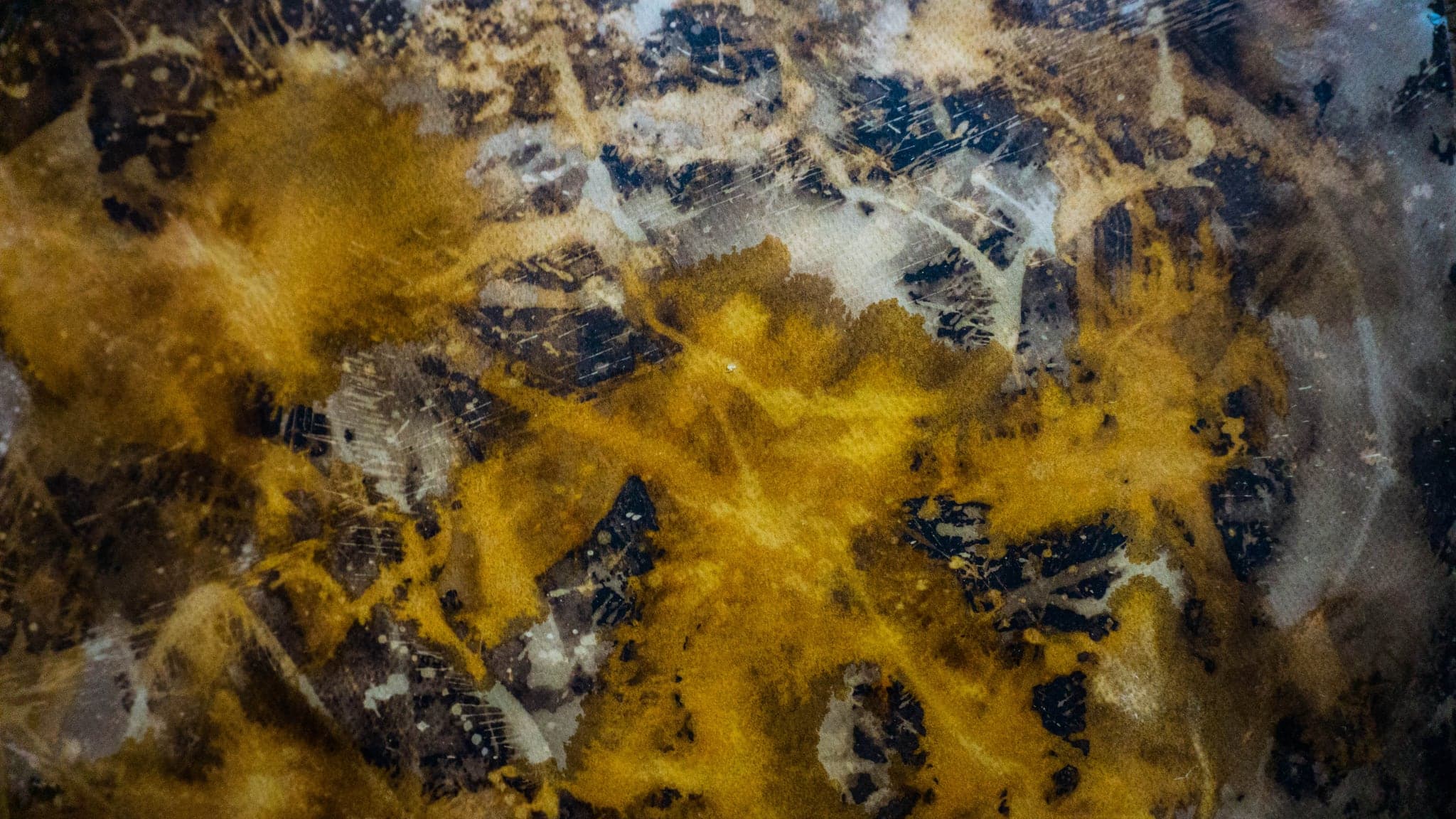 The same surface again, a gold burst spreading out of a dark mass.
