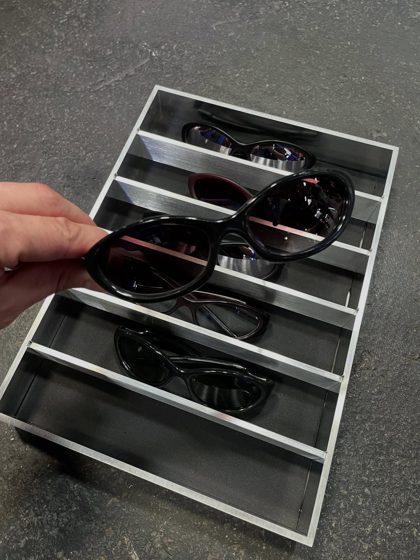 Hand lifting EVOS from an aluminum display tray of frames