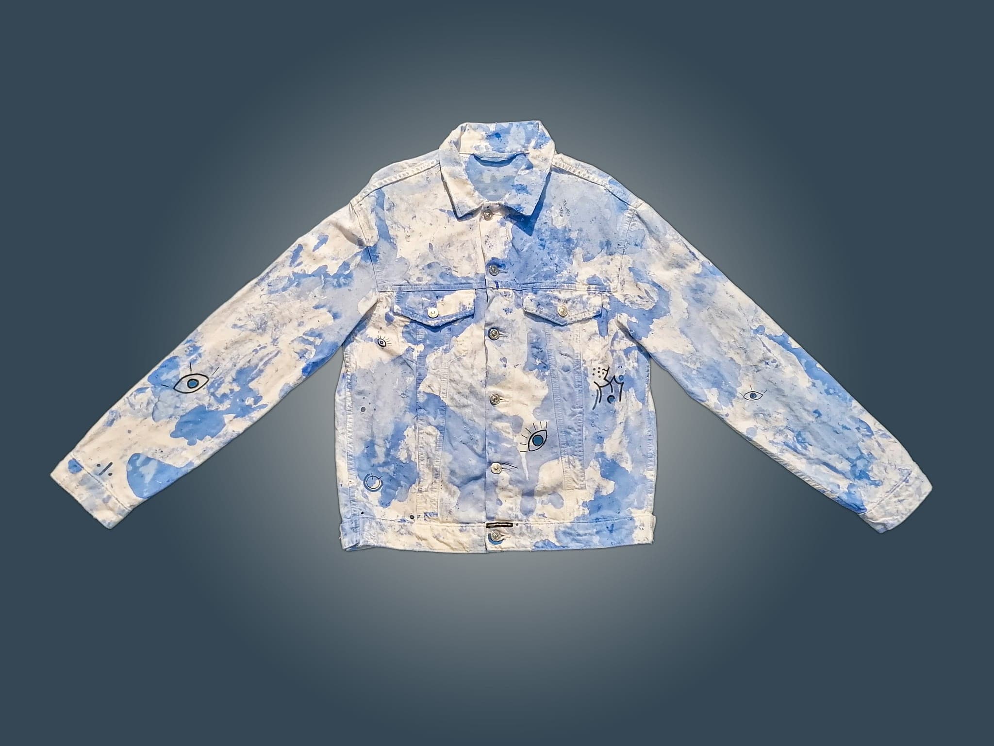 The jacket flat, indigo bleached away in soft cloud banks with the white of the denim showing through