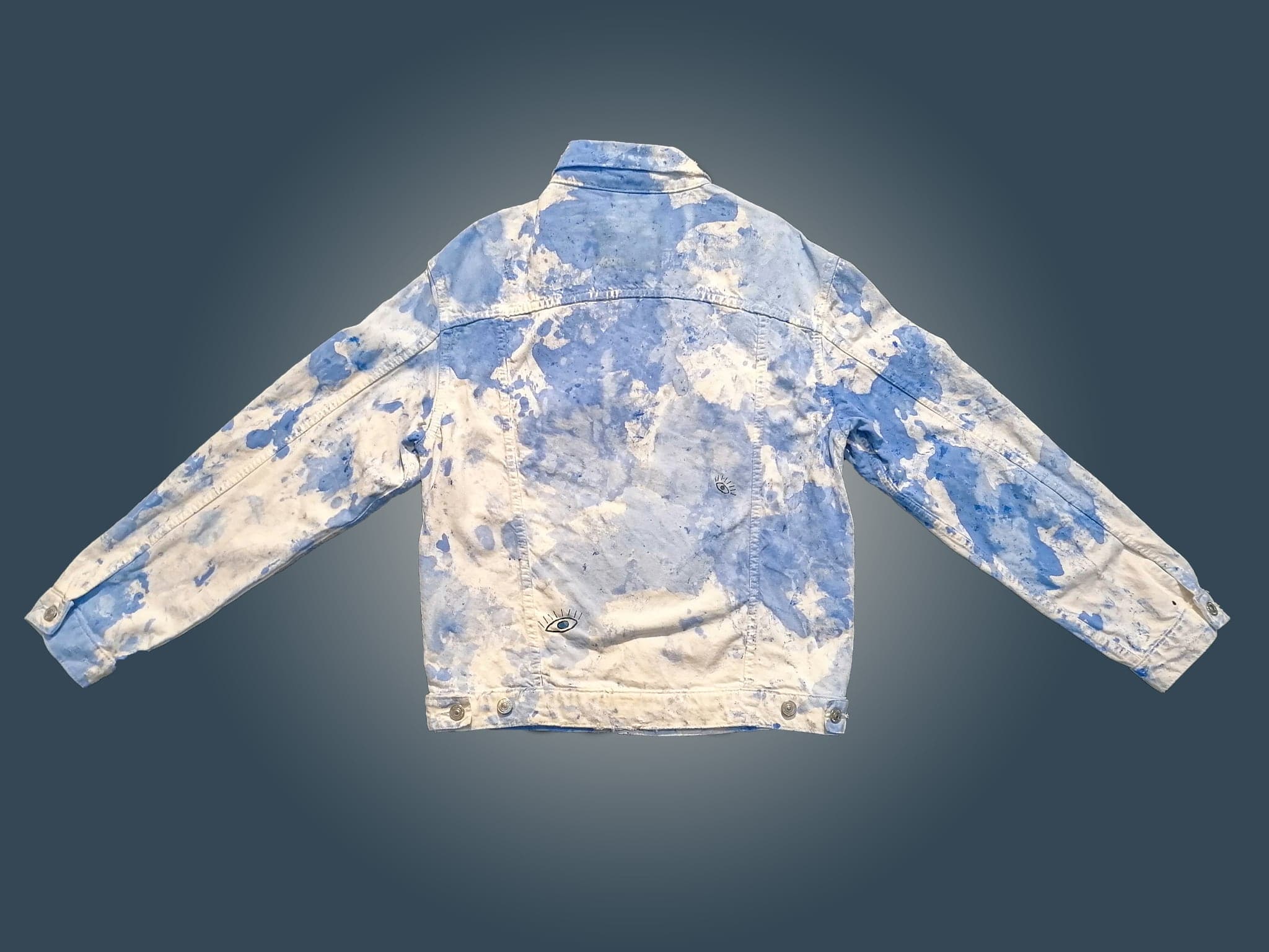 The jacket flat and spread, the pale areas reading as sky across the chest and sleeves