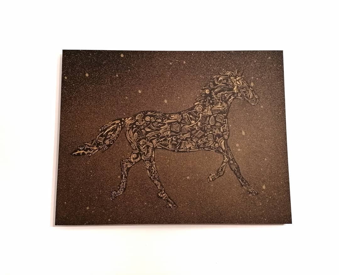 The same sheet held at an angle, the gold marks catching along the length of the body