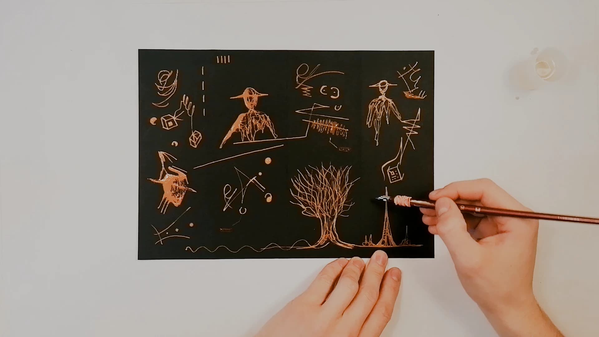 The sheet nearly complete. A tall thin tower has been added beside the tree, and a wavy line runs the full width of the bottom edge. A hand holds the paper flat at the lower right.