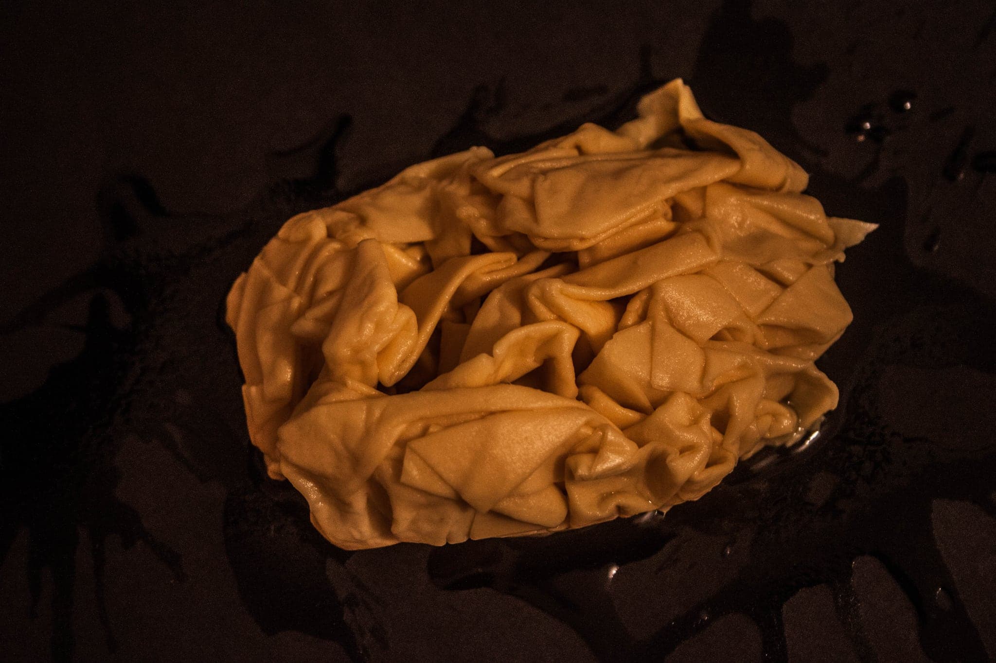 The bundle sitting in a shallow dark pool, soaked through and gone the colour of tea.