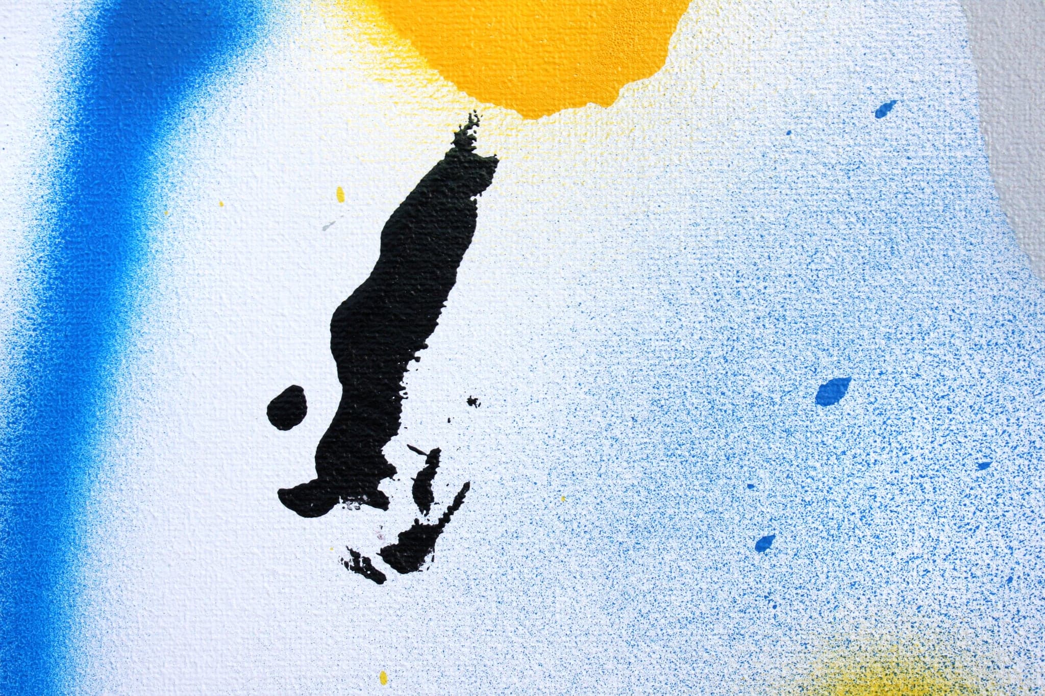 Close view: the black mark against blue haze, the yellow blob beside it.
