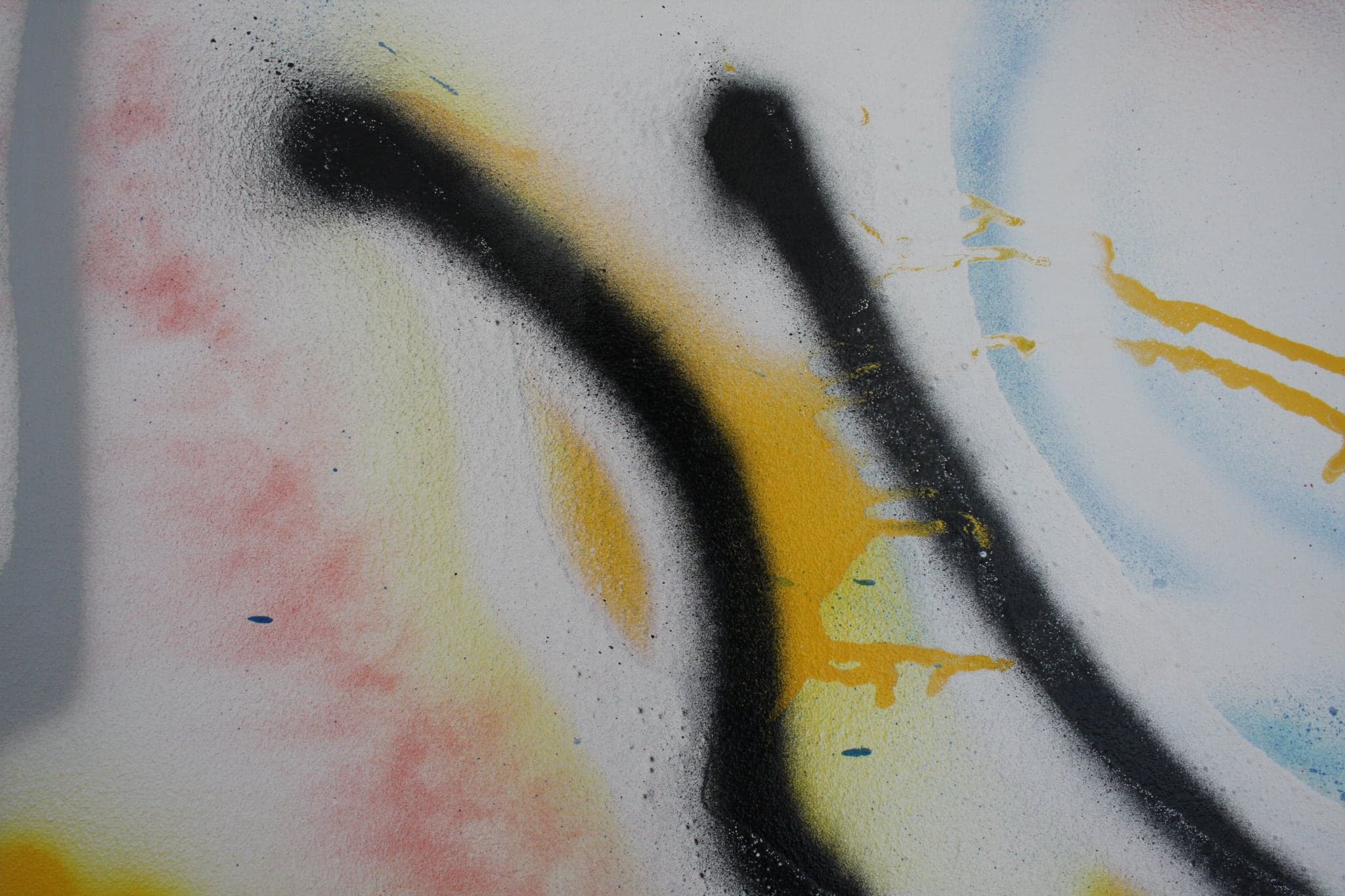 Close view: black strokes over the pale blue haze, a thin yellow line curling between them.