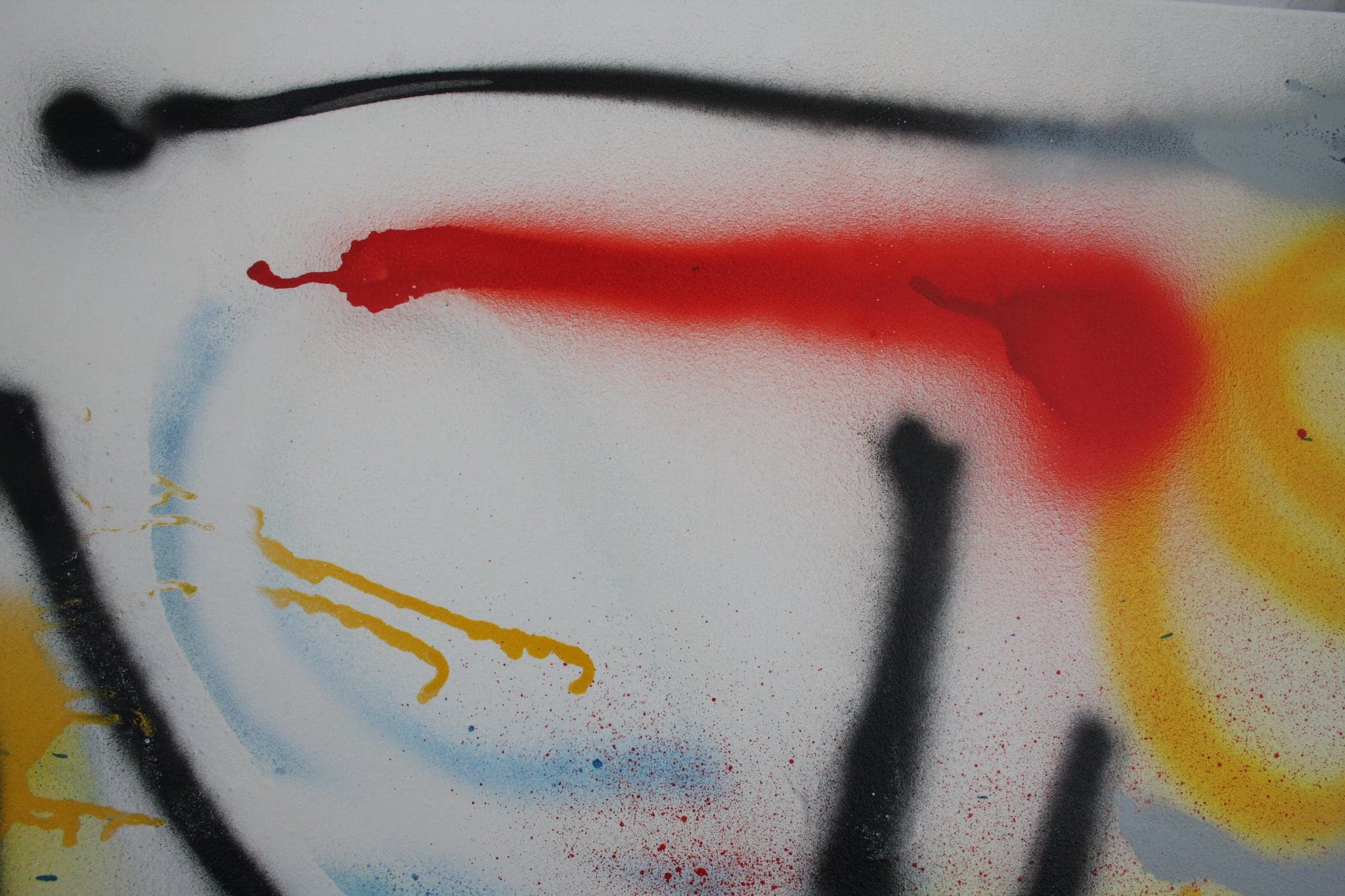 Close view: black, red and yellow meeting, with blue drifting at the edge of the spray.