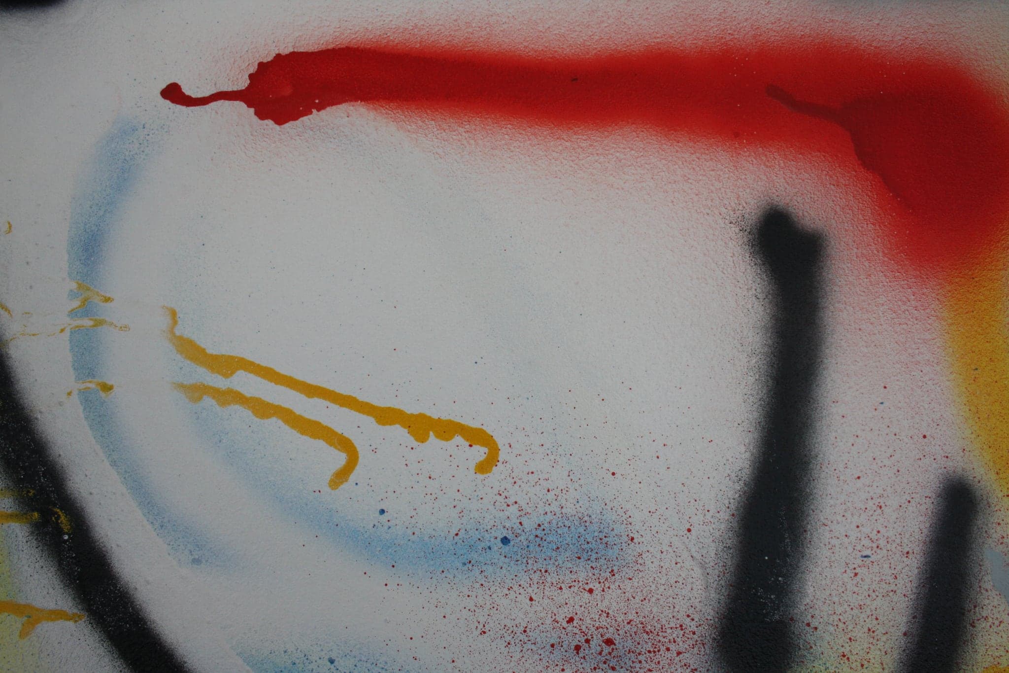 Close view: the red mass at the end of a long black stroke, yellow trailing away beneath it.