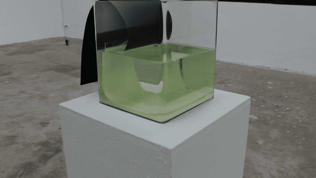 The same piece seen from the left, the far end of the black strip hanging down the outside of the tank