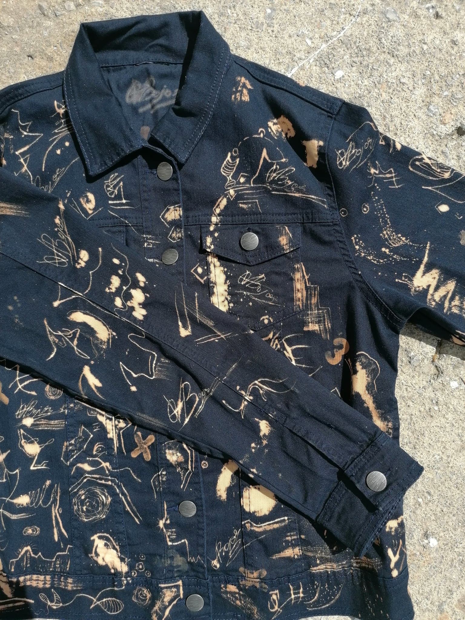 A folded sleeve lying across the body of the jacket, marks running over the seam without breaking