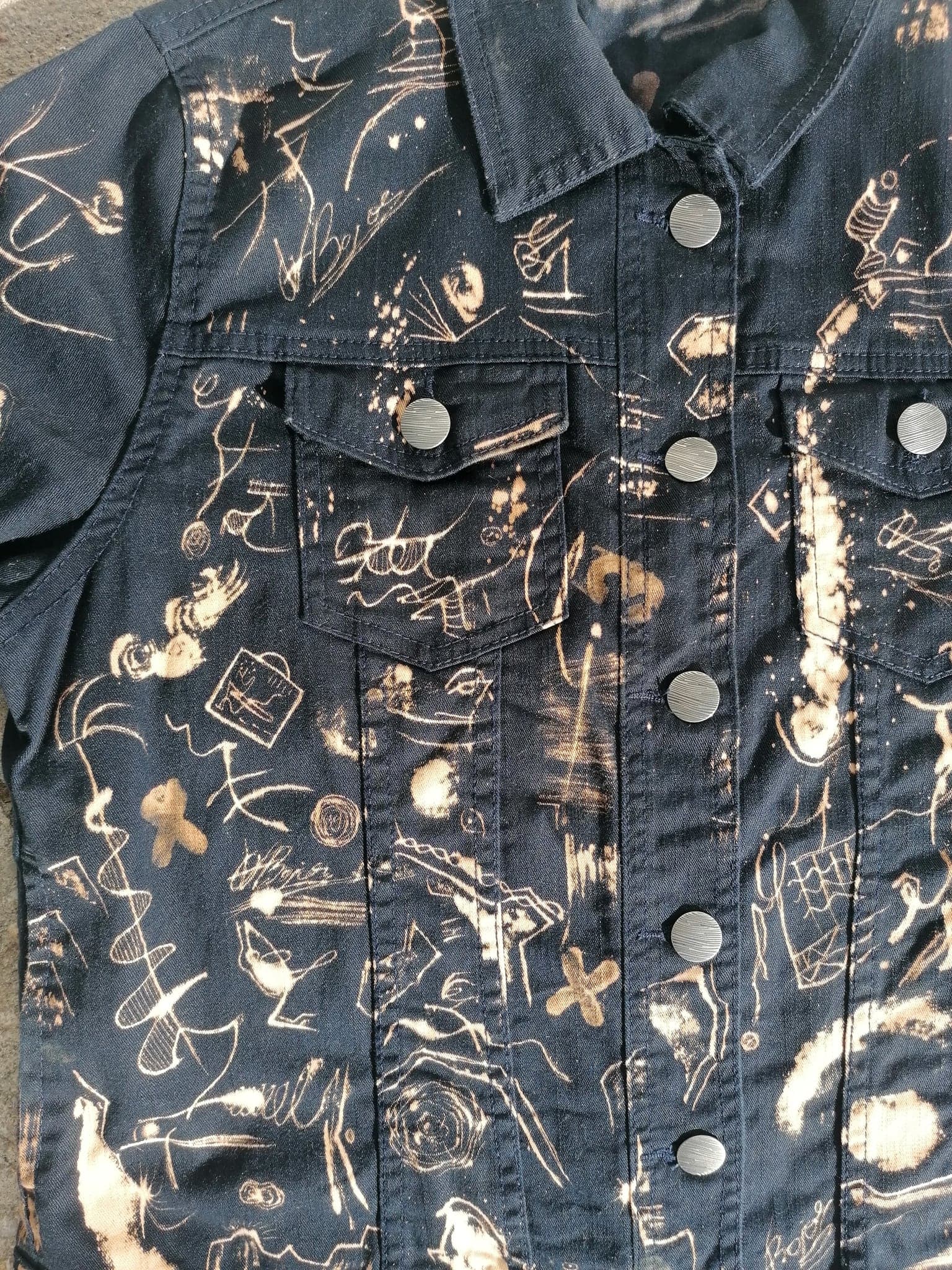 The button placket close up, a row of steel buttons with bleached marks running between them