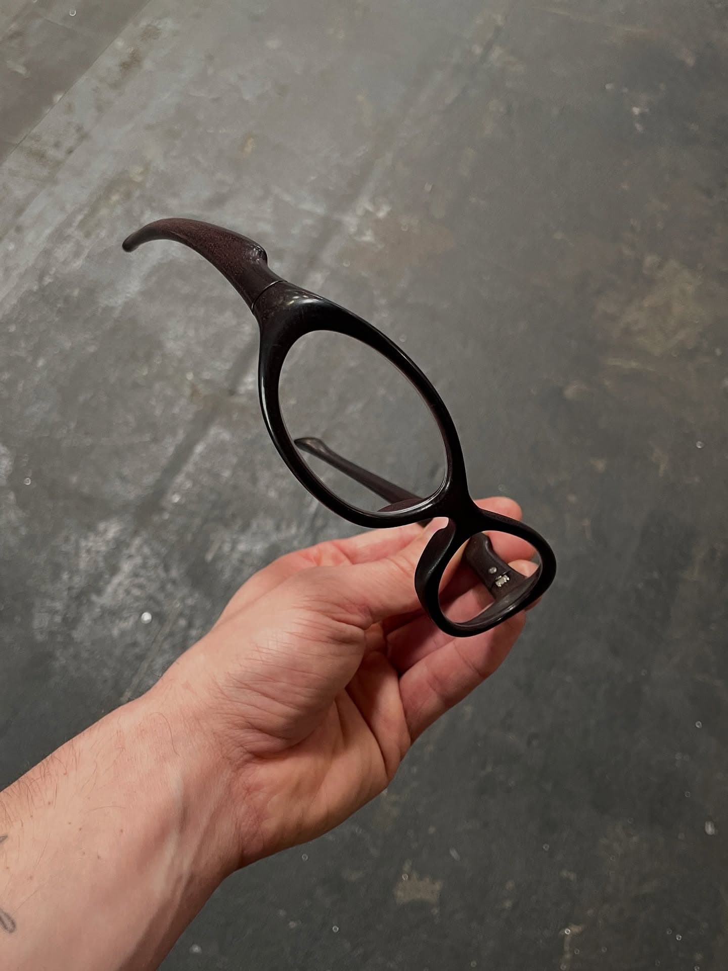 An EVOS frame held up in one hand against a concrete floor
