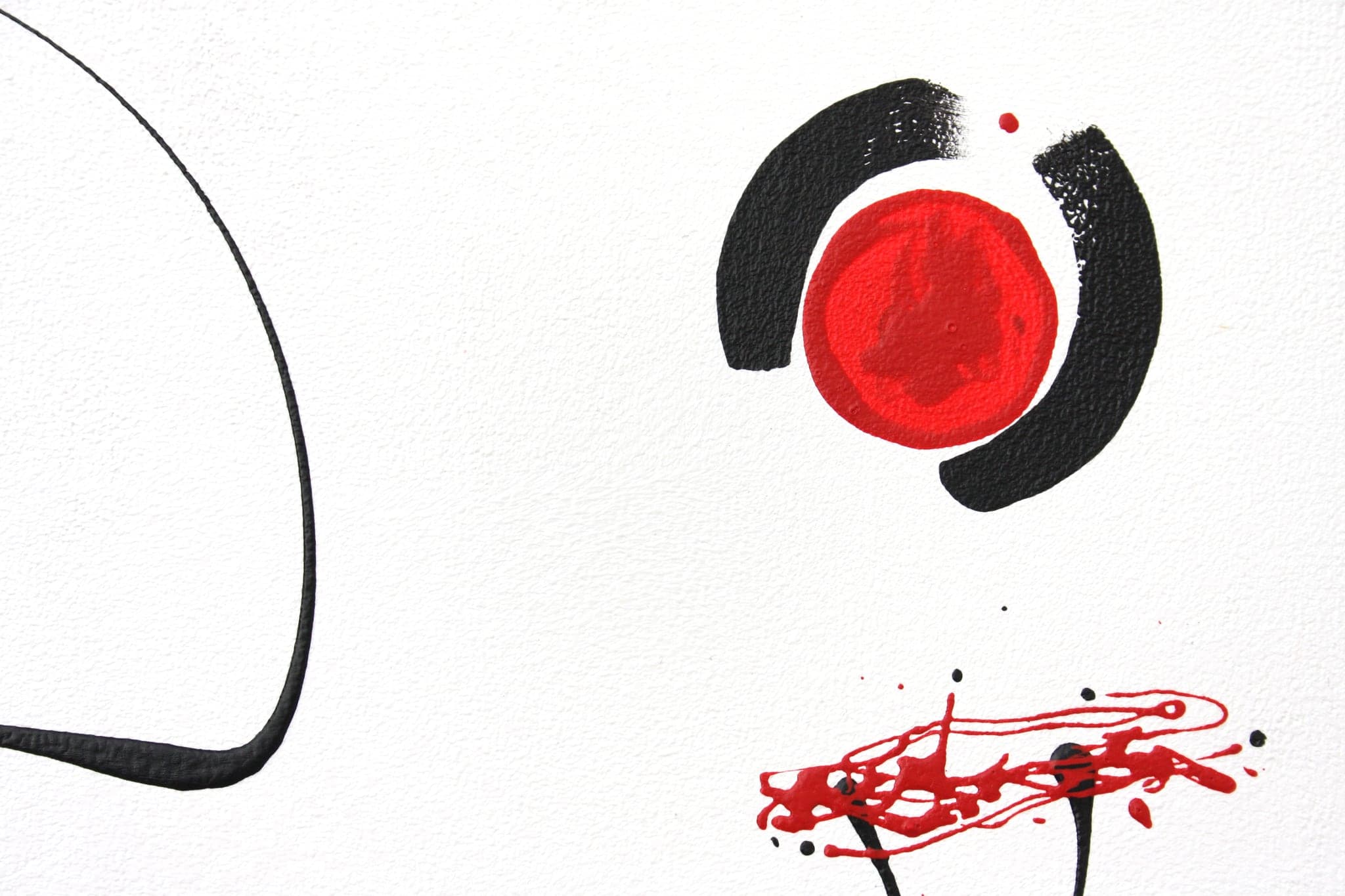 Close view of a black ring around a solid red disc, with a red splash below it